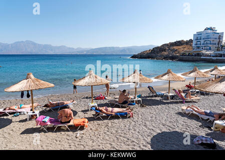 Agios Nikolaos, Crete, Greece, Tourists on the Kitroplatia municipal beach close to the town centre. October 2017 Stock Photo