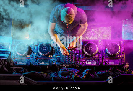 Handsome DJ playing on CD players during party. Stock Photo