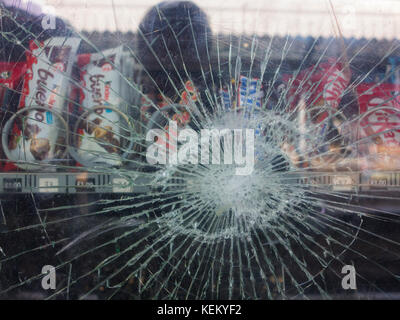 A smashed vending machine on a station platform Stock Photo