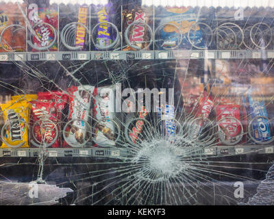 A smashed vending machine on a station platform Stock Photo