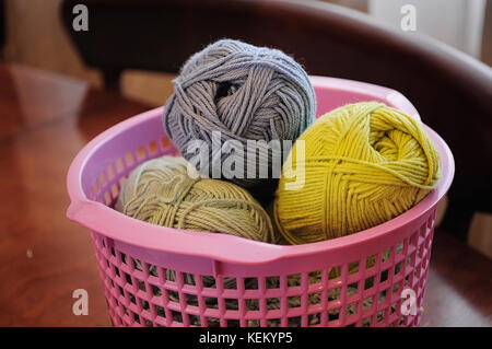 Clumps of yarn and knitting needles on the table Stock Photo
