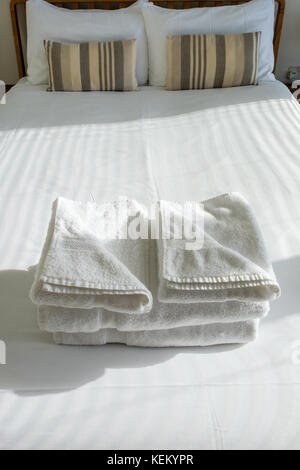 Folded guest towels on a bed Stock Photo