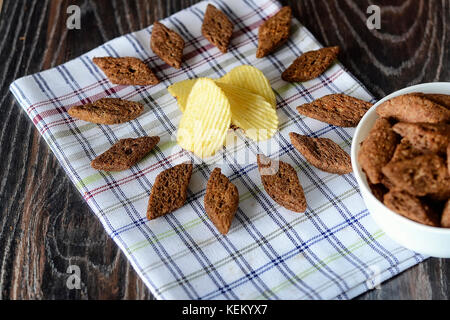 Salty snacks on a wooden texture background Stock Photo