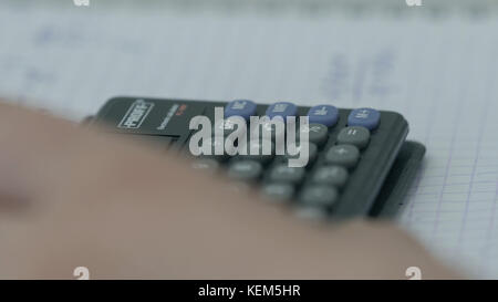 Girl considers checks on the calculator. Hands woman calculator money. Female office workers holding are arranging documents of unfinished documents archive analyzing the market Stock Photo