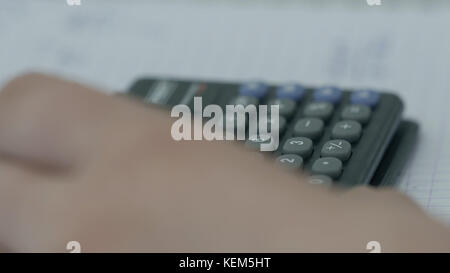 Girl considers checks on the calculator. Hands woman calculator money. Female office workers holding are arranging documents of unfinished documents archive analyzing the market Stock Photo