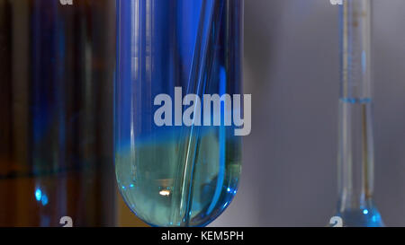 Scientist Pours Blue Pattern Chemicals Into In Flask. health care and medical concept. Scientist are certain activities on experimental science like mixing chemicals Stock Photo