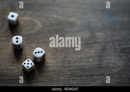 White dices on a brown wooden texture table Stock Photo