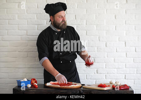 Bearded chef chef prepares meals Stock Photo