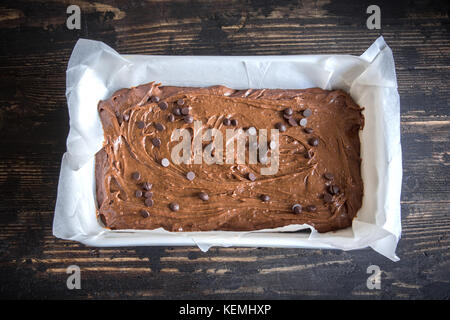 Basic homemade brownie or chocolate cake raw dough in baking pan. Cooking (baking) homemade chocolate cake or brownie. Stock Photo