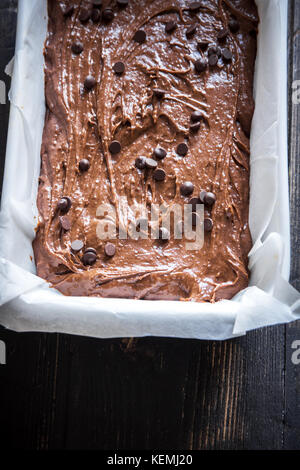 Basic homemade brownie or chocolate cake raw dough in baking pan. Cooking (baking) homemade chocolate cake or brownie. Stock Photo