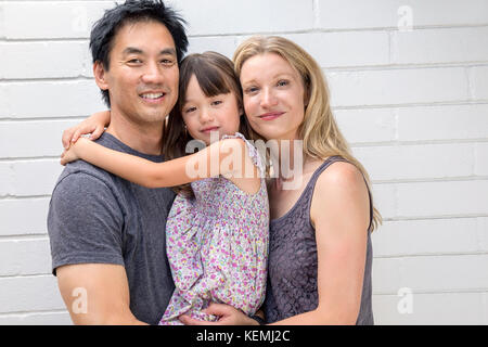 Parents holding their five year old daughter Stock Photo