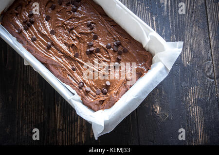 Basic homemade brownie or chocolate cake raw dough in baking pan. Cooking (baking) homemade chocolate cake or brownie. Stock Photo