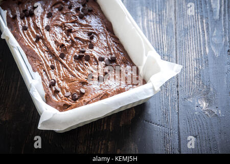 Basic homemade brownie or chocolate cake raw dough in baking pan. Cooking (baking) homemade chocolate cake or brownie. Stock Photo