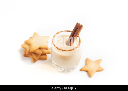 Eggnog with cinnamon and nutmeg for Christmas and winter holidays. Christmas Eggnog, gingerbread cookies isolated on white background. Stock Photo