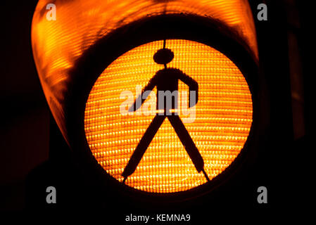 Orange traffic light with icon of walking pedestrian Stock Photo