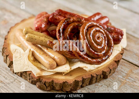 Grilled appetizing sausages on platter. Octoberfest traditional food. Tasty grilled sausages, german food. Delicious fried sausages on board. Stock Photo