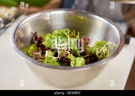 Mixed salad leaves in stainless bowl. Fresh mix of green and purple salad on table close up. Dish cooking at restaurant. Stock Photo