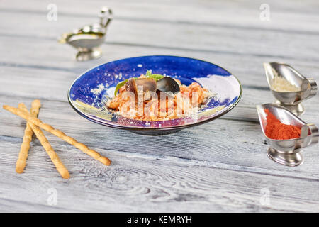 Delicious pasta on plate and spices. Appetizing italian spaghetti with mussels in restaurant. Stock Photo