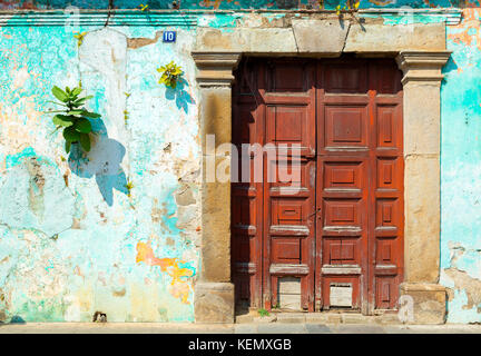 Wooden door in rustic blue spanish colonial wall, Antigua, Guatemala, Central America Stock Photo