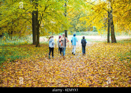 Running athletes in the park on a run in the early morning. Several children are running in the woods doing sports. Healthy lifestyle. Stock Photo