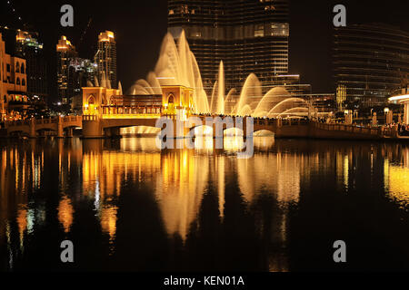 Dubai Fountain Show, taken at night in Dubai Downtown, United Arab Emirates. Photo is in contrasting colors - gold and black. Stock Photo