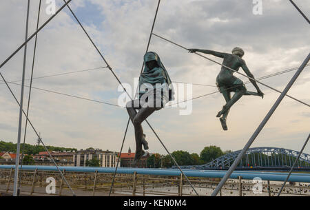 KRAKOW, POLAND-AUGUST 3, 2017: Krakow's Father Bernatek footbridge.The nine acrobatic figures form the exhibition entitled Between the water and the s Stock Photo