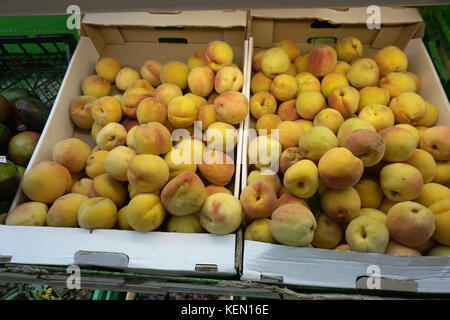 boxes of peaches on the shelf in the store Stock Photo