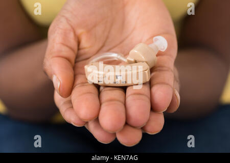 Close-up Of Hearing Aid On Person Palm Stock Photo