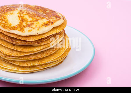 High stack of fried pancakes on pink background. Studio Photo Stock Photo