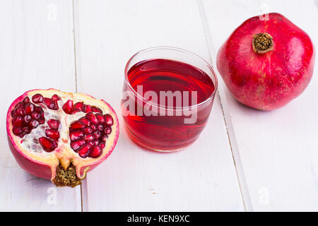 Pomegranate and juice in glass on white wooden background. Studio Photo Stock Photo
