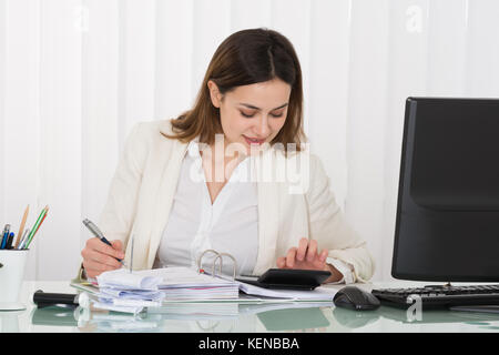 Photo Of Happy Businesswoman Calculating Bills In Office Stock Photo
