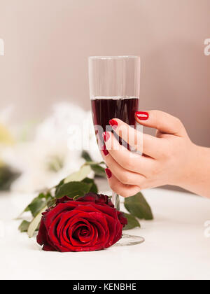 Beautiful woman hand with polished nais holding glass of red wine Stock Photo