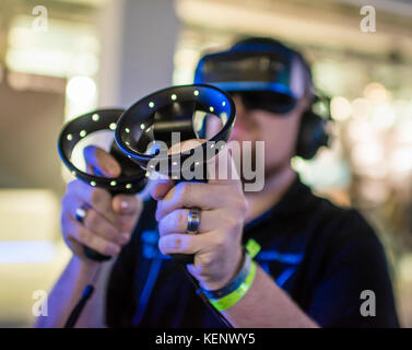 Zurich, Switzerland. 22nd Oct, 2017. A visitor of the Zurich Game Show 2017 at Zurich's exhibition centre is trying out a virtual reality game using a VR headset and Microsoft motion controllers. Credit: Erik Tham/Alamy Live News Stock Photo