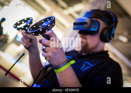 Zurich, Switzerland. 22nd Oct, 2017. A visitor of the Zurich Game Show 2017 at Zurich's exhibition centre is trying out a virtual reality game using a VR headset and Microsoft motion controllers. Credit: Erik Tham/Alamy Live News Stock Photo