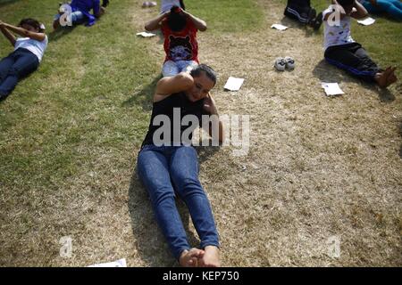 Lalitpur, Nepal. 23rd Oct, 2017. Nepalese women perform sit-ups during a training exercise for the selection of temporary cops for the upcoming provincial and parliamentary elections in Lalitpur, Nepal on Monday, October 23, 2017. The government of Nepal is recruiting 98, 168 temporary police for the upcoming elections. Credit: Skanda Gautam/ZUMA Wire/Alamy Live News Stock Photo