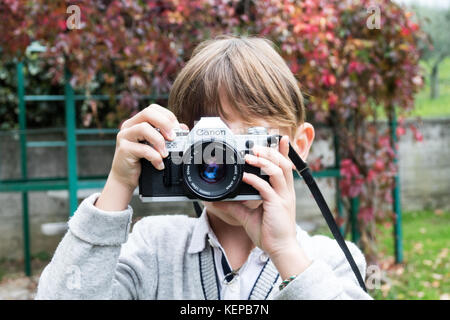 Trieste, Italy - October 22th 2017: Camera Canon AE-1 35mm, baby taking pictures using vintage film camera Stock Photo