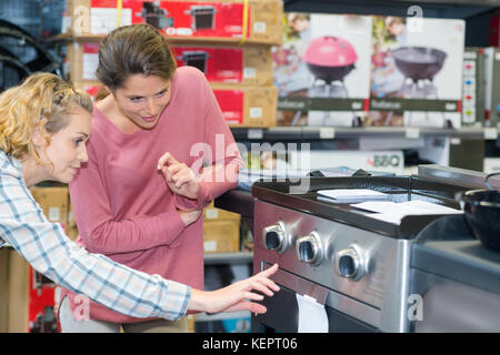 couple choosing kitchen oven in store and smiling Stock Photo