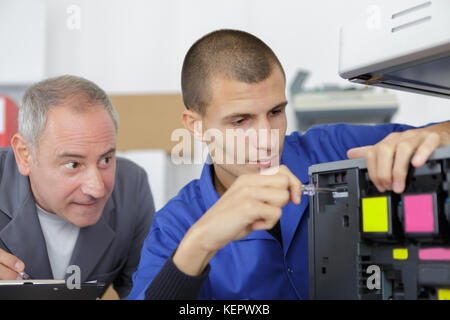 young apprentice fixing cartridge in photocopy machine Stock Photo