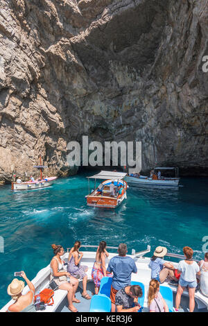 tourists on boat trips visit grotta verda on the island of capri, italy.