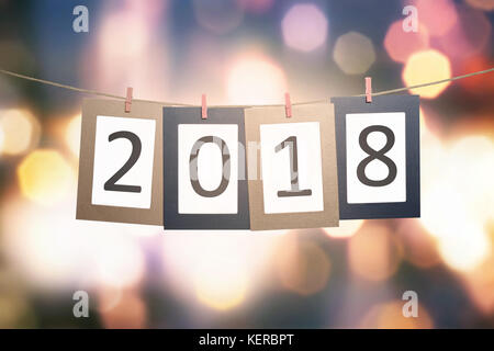 2018 number on paperboard for New Year hanging on rope with blur light background Stock Photo