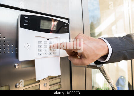 Close-up Of Businessperson Hand Entering Code In Security System Stock Photo
