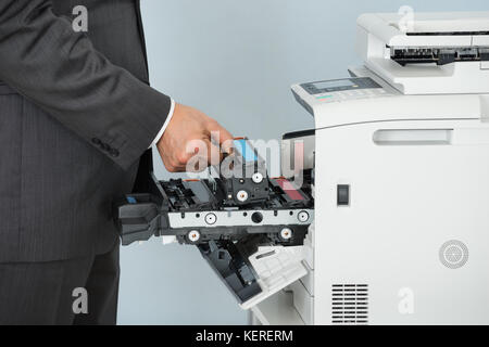 Close Up Of Businessman Hand Fixing Cartridge In Printer Machine At Office Stock Photo