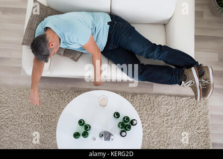 Mature Man Taking A Nap On Sofa At Home Stock Photo