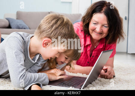 Kids Using Laptop Computer To Play Game At Home Stock Photo
