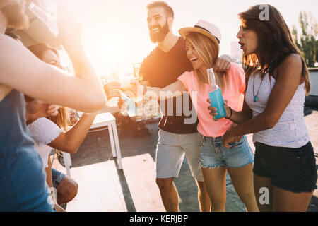 Group of happy friends having party on rooftop Stock Photo