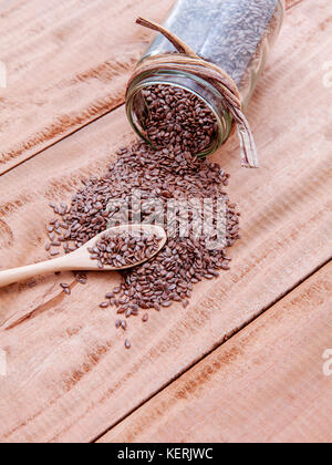 Alternative health care and dieting flax seeds in wooden spoon set up on rustic wooden background. Stock Photo