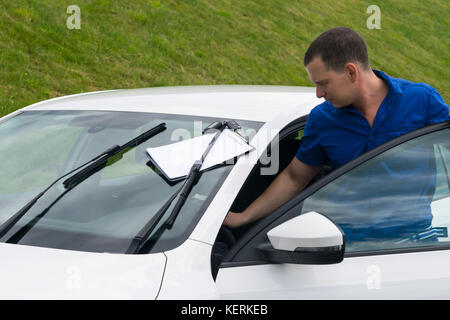 man in a blue shirt takes a white car for hire on vacation Stock Photo