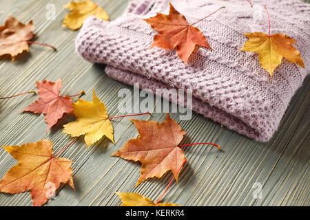 Autumn accessories knitted sweaters and leaves Stock Photo