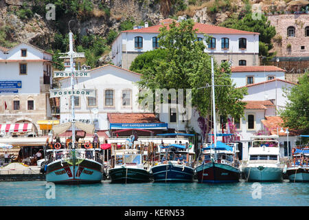 The view of the yachts and cruise boats in the old harbour of Kaleici and the sea and white buildings with red tile roofs against rocky cliffs. Stock Photo