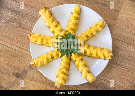 Top view of a plate of pineapple boats on a wooden table Stock Photo